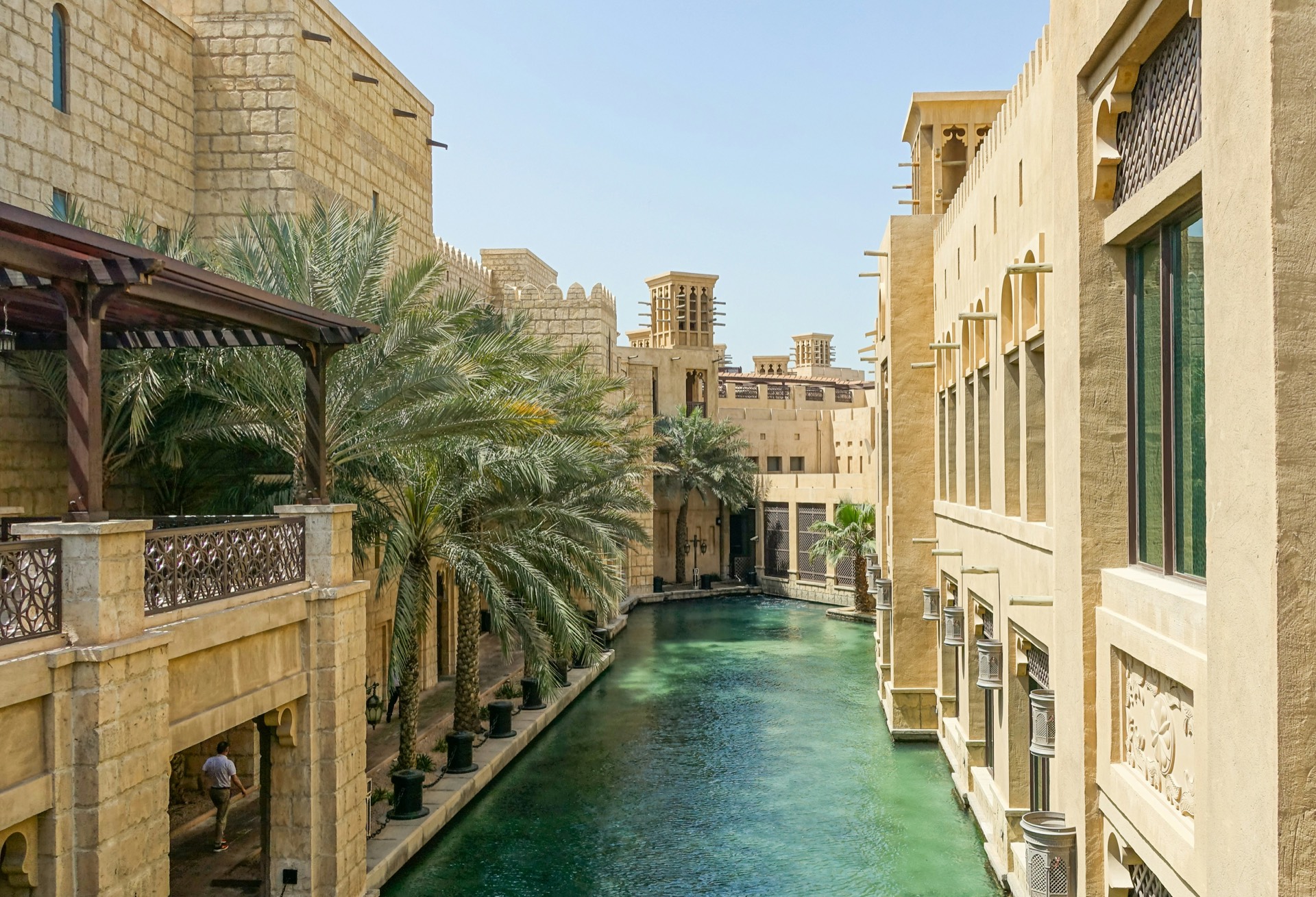Waterway lined with palms and traditional architecture in Dubai